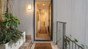 A modern entrance with a glass door leading to a hallway. - Eclectic City-Fringe Townhouse with Rooftop Deck (Auckland)
