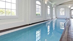 An indoor swimming pool with white walls and large windows. - Eclectic City-Fringe Townhouse with Rooftop Deck (Auckland)