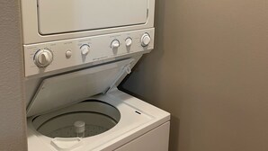 A front-loading washing machine with a control panel and a detergent dispenser on top. - Convenient and bright Cross Trail Vacation Getaway! (Sitka)