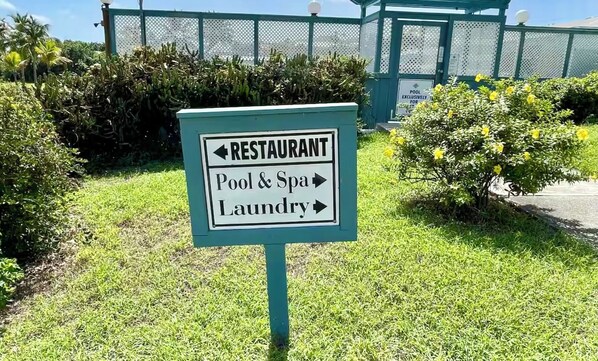 A sign indicating directions to a restaurant, pool & spa, and laundry. - Beachfront Studio Condo @Club St Croix (St Croix)
