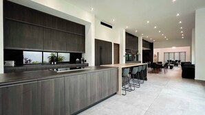 Una cocina moderna con armarios oscuros, una isla central y asientos de bar.