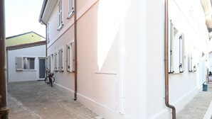 Eine schmale Straße mit Häusern an beiden Seiten, ein Fahrrad und eine sichtbare Tür.