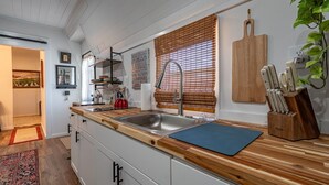 Een moderne keuken met een houten aanrecht, een roestvrijstalen spoelbak en een snijplank.