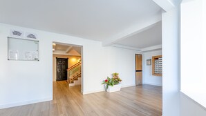 Ein geräumiger Flur mit Holzboden, weißer Wand und einer Treppe zu einem anderen Raum.