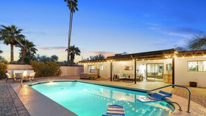 A swimming pool with lounge chairs and a covered patio area. - Scottsdale Day Dream - Spacious modern home with Private Pool, Hot Tub, and Firepit (Scottsdale)