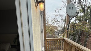 A wooden deck with a railing, a door leading to a bedroom, and a satellite dish on the roof. - Stylish Townhouse by Carrol Park, M&T Bank Stadium (Baltimore)