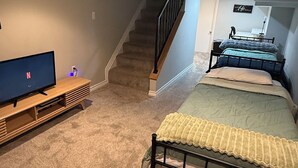 A bedroom with a bed, a TV, a staircase, and a desk. - Stylish Townhouse by Carrol Park, M&T Bank Stadium (Baltimore)