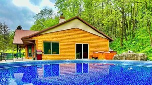 A wooden cabin with a swimming pool, surrounded by trees. - Yellow River Lodge 6-bedroom cabin w/Pool &Hot Tub & Pool Table (Waterville)