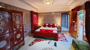 Een klassieke kamer met een bed, een tafel en een kroonluchter.