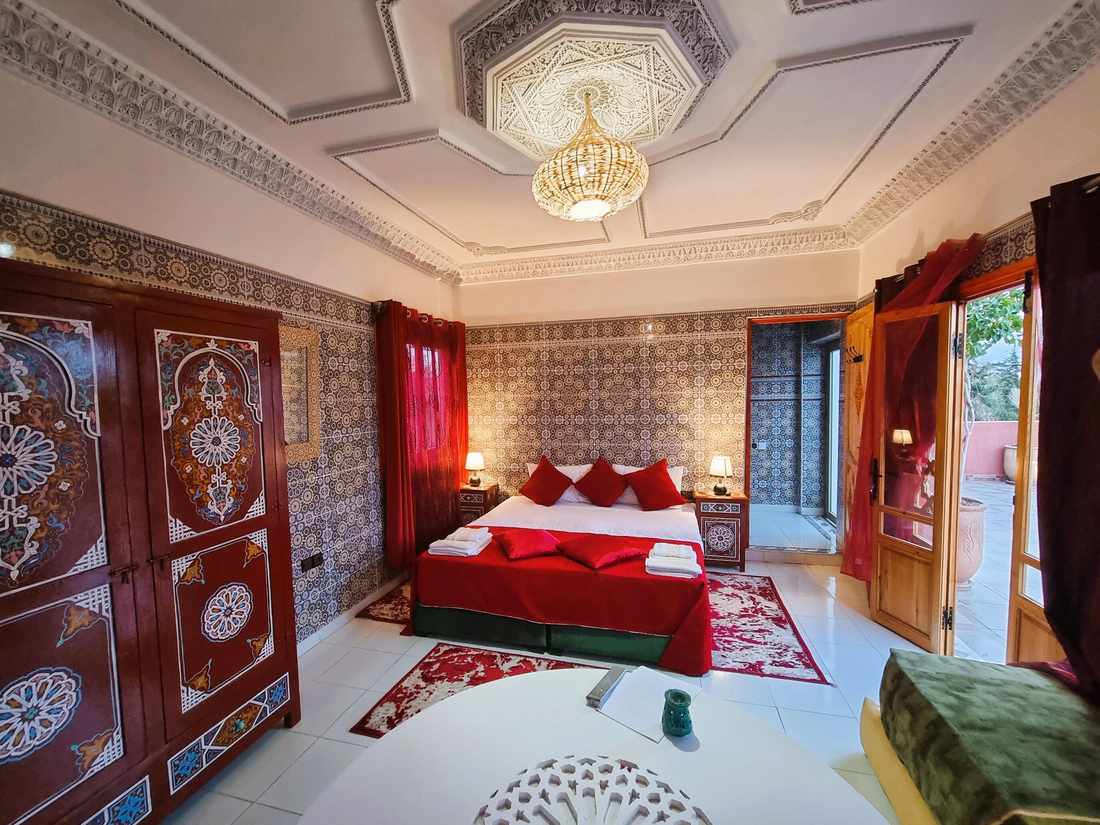 A traditional room with a bed, a table, and a chandelier.