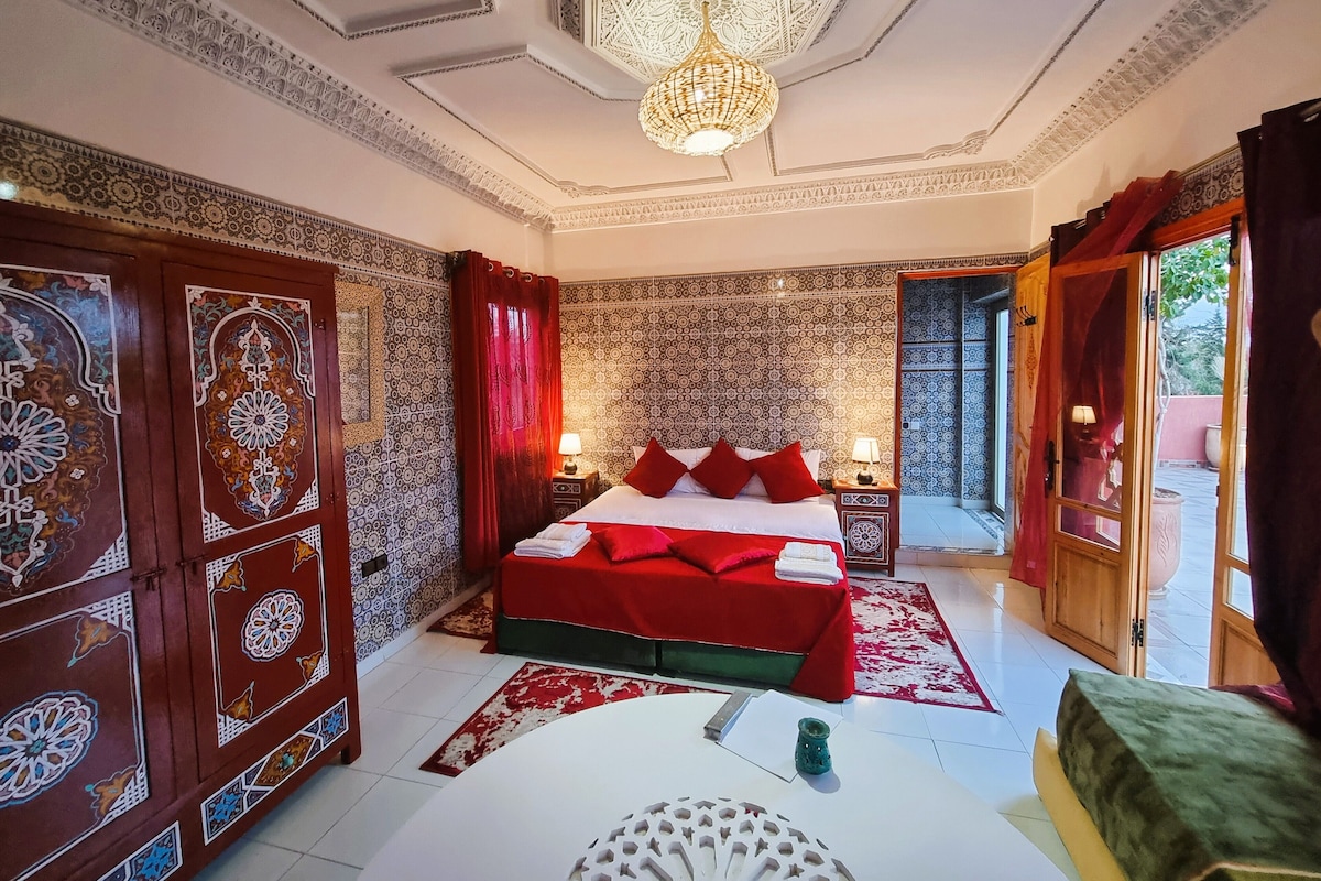 A traditional room with a bed, a table, and a chandelier.