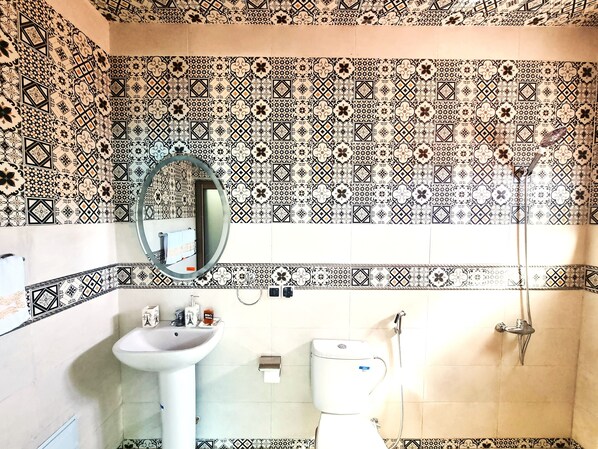 A bathroom with patterned tiles, a sink, a toilet, and a shower. - Hôtel & Restaurant Villa des étoiles (Ourika)