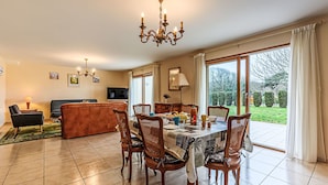 A dining area with a table set for four, surrounded by wooden chairs. - Le Prat by Interhome (Guidel)