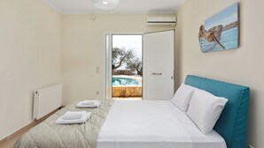 Une chambre avec un lit, donnant sur une piscine extérieure, et une porte menant à l’extérieur.