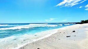 Una playa con aguas azules cristalinas y una orilla arenosa.