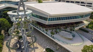 Un edificio moderno con una escalera espiral única y una amplia plaza abierta con zonas de estar.