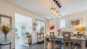 Un salon moderne avec un coin repas, comprenant une grande fenêtre, un canapé, une table basse et une table à manger avec des chaises.