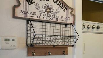 Et vægmonteret skilt med en bi og teksten "OUR GUEST MAKE YOURSELF AT HOME".
