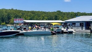 A dock with boats, a covered area, and a sign that reads "What's up dock?". - Lakeview Getaway at Kimberling Crossing (Kimberling City)