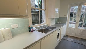 A kitchen with a washing machine, a sink, and a window. - House - Sleeps 5- Garden - Parking (Windsor)