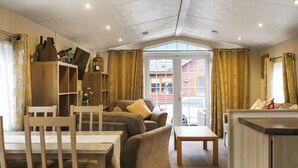 Un salon chaleureux avec un canapé, une table en bois et une bibliothèque.