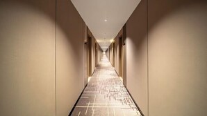 A long, narrow hotel corridor with a patterned floor and evenly spaced doors on both sides. - Shanghai Eagle Hotel (Shanghai)