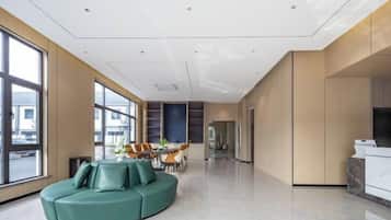 Un interior moderno con una zona de estar curvada, una mesa de comedor y una cocina.