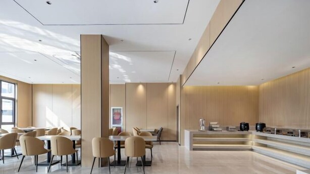 A modern hotel lobby with a central seating area, a reception desk, and a large window providing natural light. - Shanghai Eagle Hotel (Shanghai)