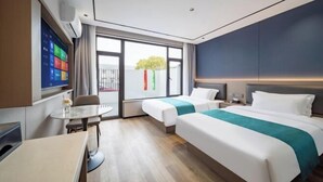 A hotel room with two beds, a small table, a TV, and a window with a view. - Shanghai Eagle Hotel (Shanghai)