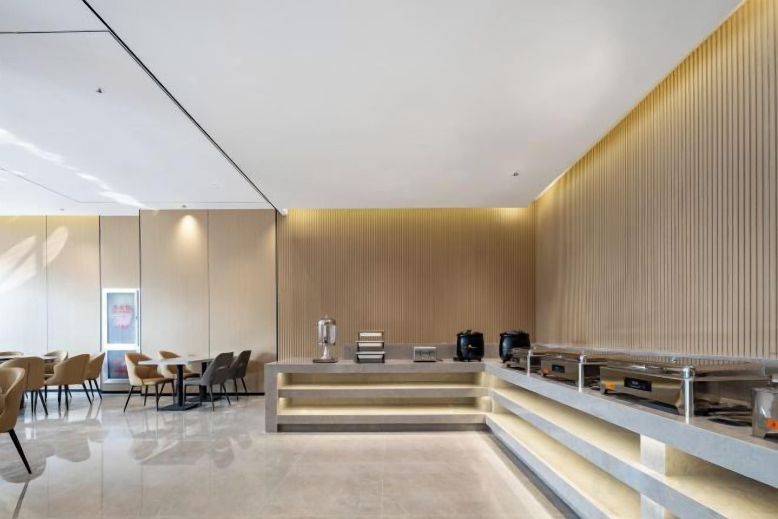 A modern reception area with a counter, seating, and a wall with vertical lines.