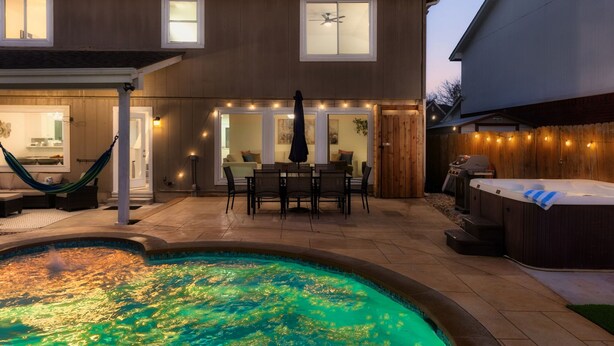 Una casa moderna con piscina, mobiliario exterior y jacuzzi.
