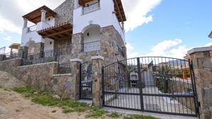 A two-story house with stone walls and a black metal gate. - Amazing apartment in Olia Speciosa with WiFi (Olia Speciosa)