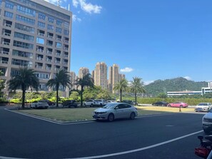 A parking lot with multiple cars, a building with numerous windows, and a clear blue sky. - Keymore Residence Guangzhou (Guangzhou)