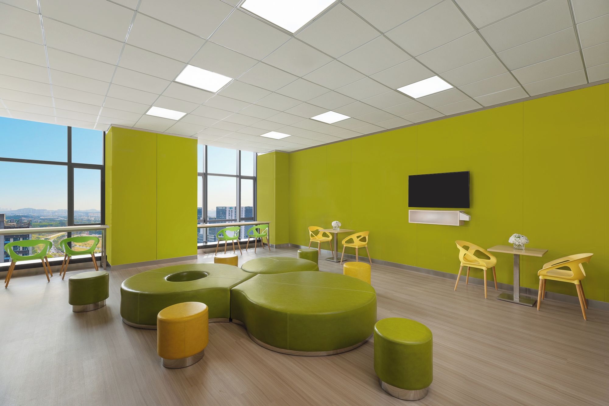 A modern interior with green walls, a large window, and a flat-screen TV.