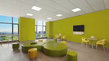 A modern interior with green walls, a large window, and a flat-screen TV.
