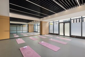 A modern yoga studio with large windows, a wooden ceiling, and pink yoga mats arranged on the floor. - Keymore Residence Guangzhou (Guangzhou)
