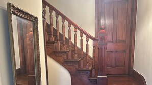 A wooden staircase with a handrail and a light fixture above it.