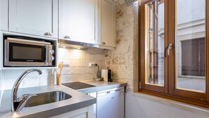 A kitchen with white cabinets, a stainless steel sink, a microwave, and a dishwasher.