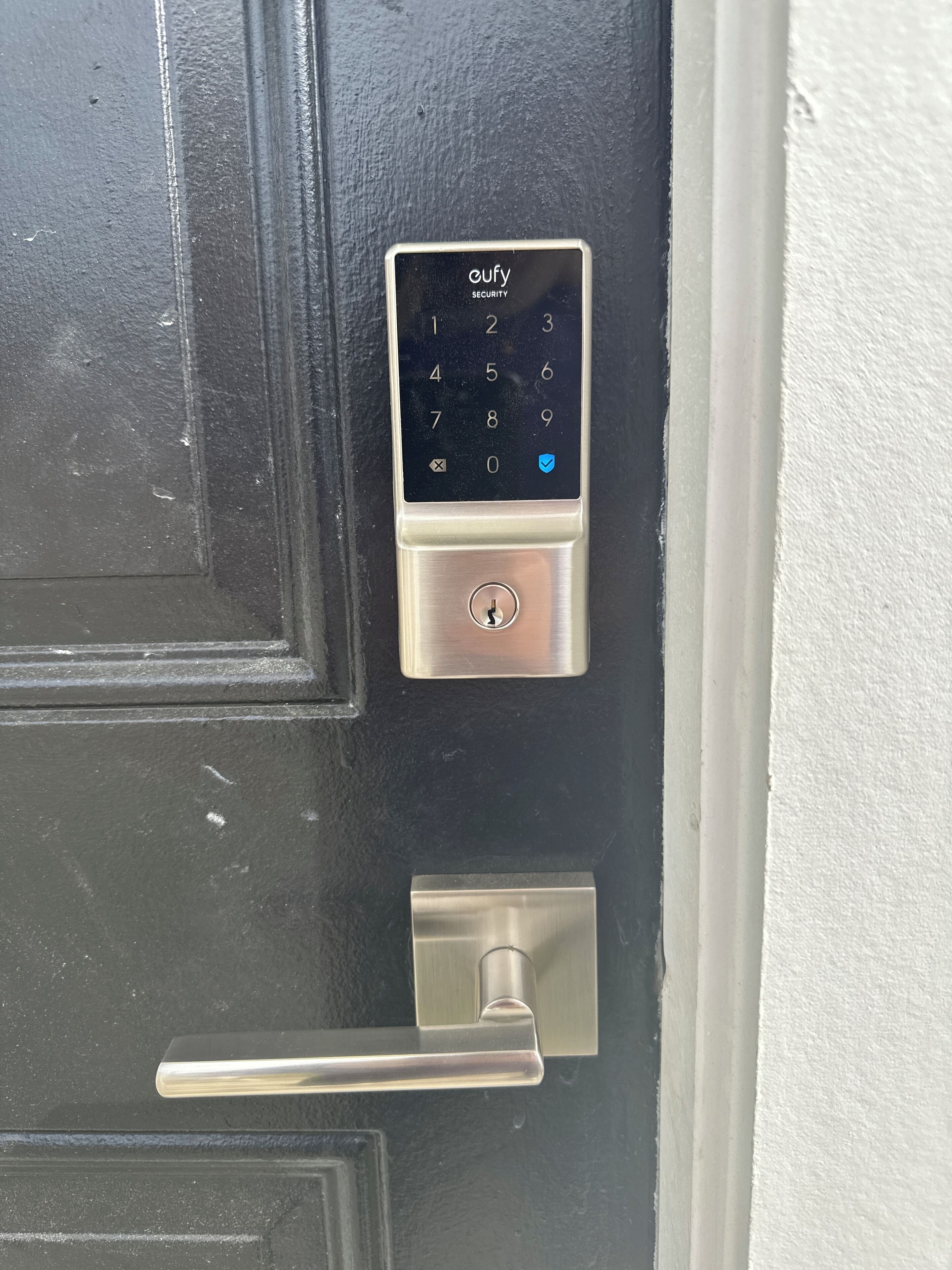 A door with a keypad lock labeled "oufy SECURITY".