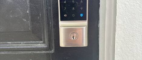 A door with a keypad lock labeled "oufy SECURITY".