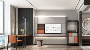 A modern hotel room with a large window, a desk with a chair, a vanity with a mirror, and a shower area. - UrCove by Hyatt Lianyungang Railway Station Suning Plaza (Lianyungang)