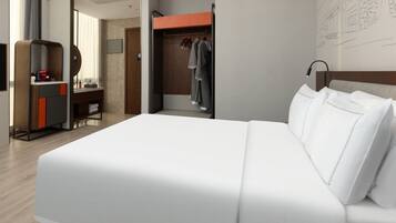 A modern hotel room with a large bed, a wardrobe, a desk with a chair, and a mirror.