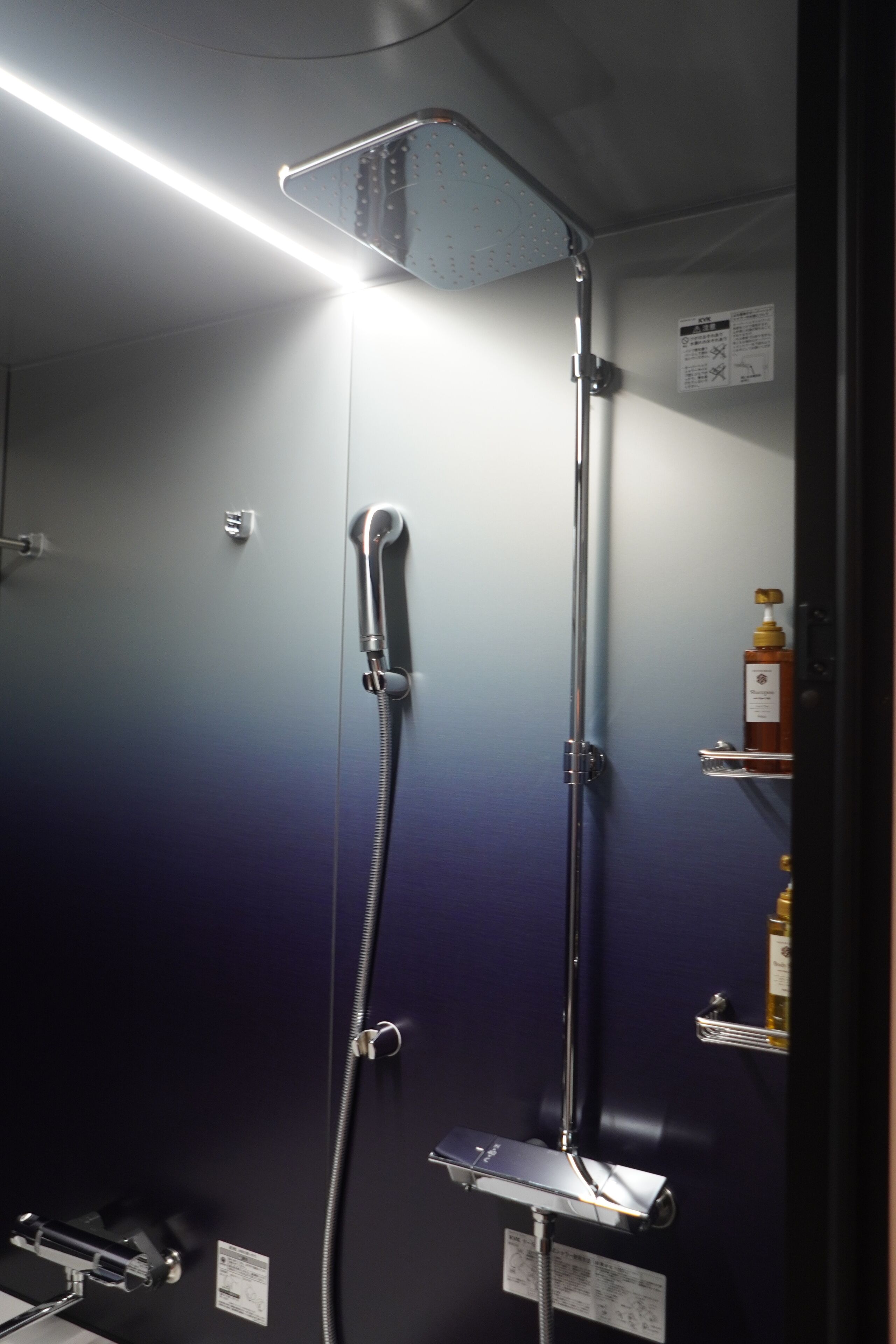 Een douche met een handdouche en een wandmengkraan.