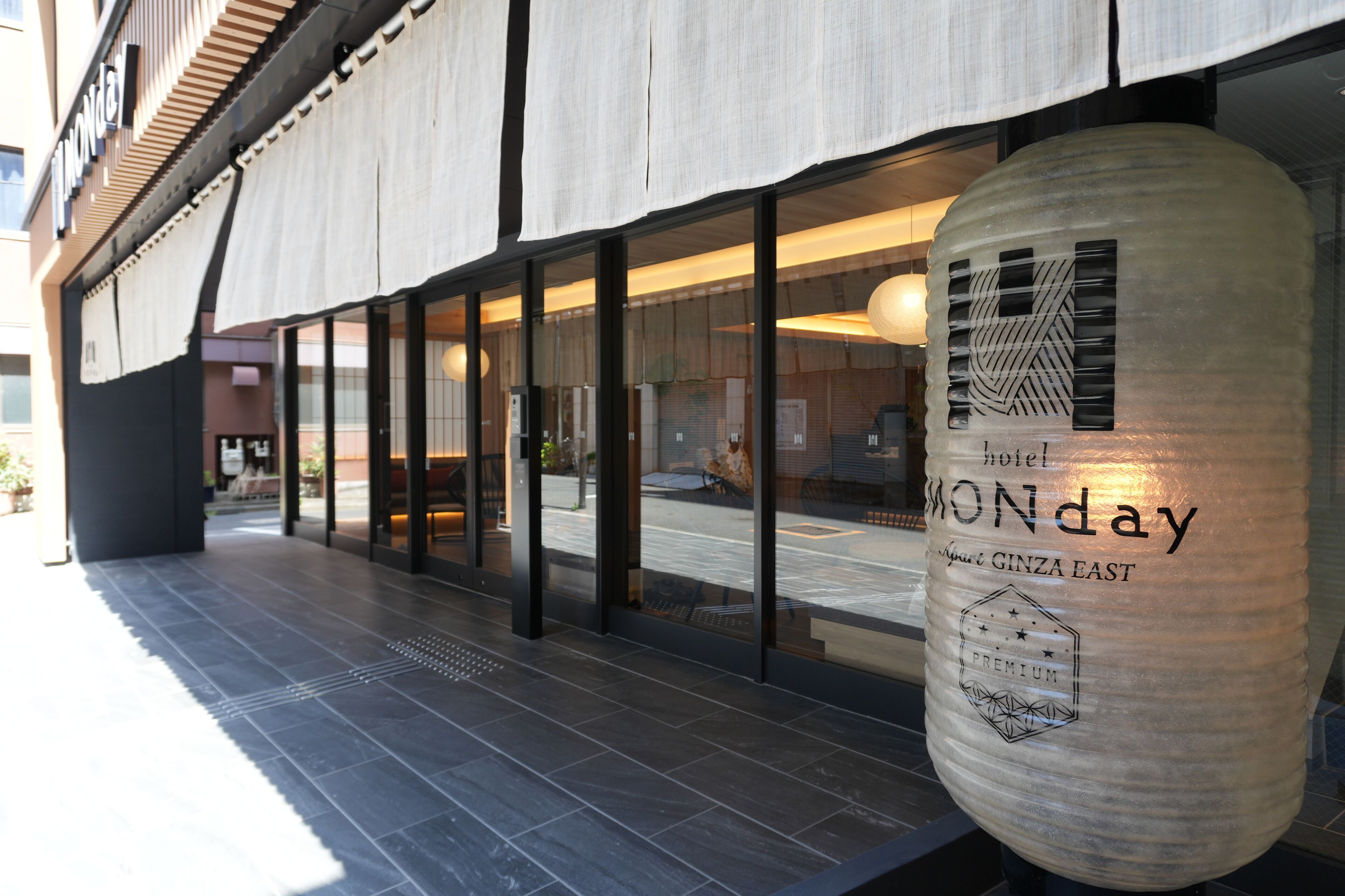 Exterior d'un hotel amb grans finestres de vidre, un cartell destacat amb el nom 