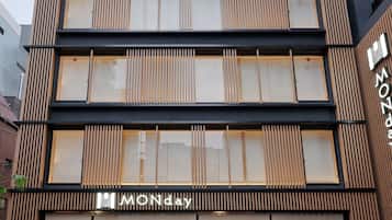 A modern building with a prominent "MONday" sign, featuring a clean, contemporary design with vertical wooden slats and large windows.