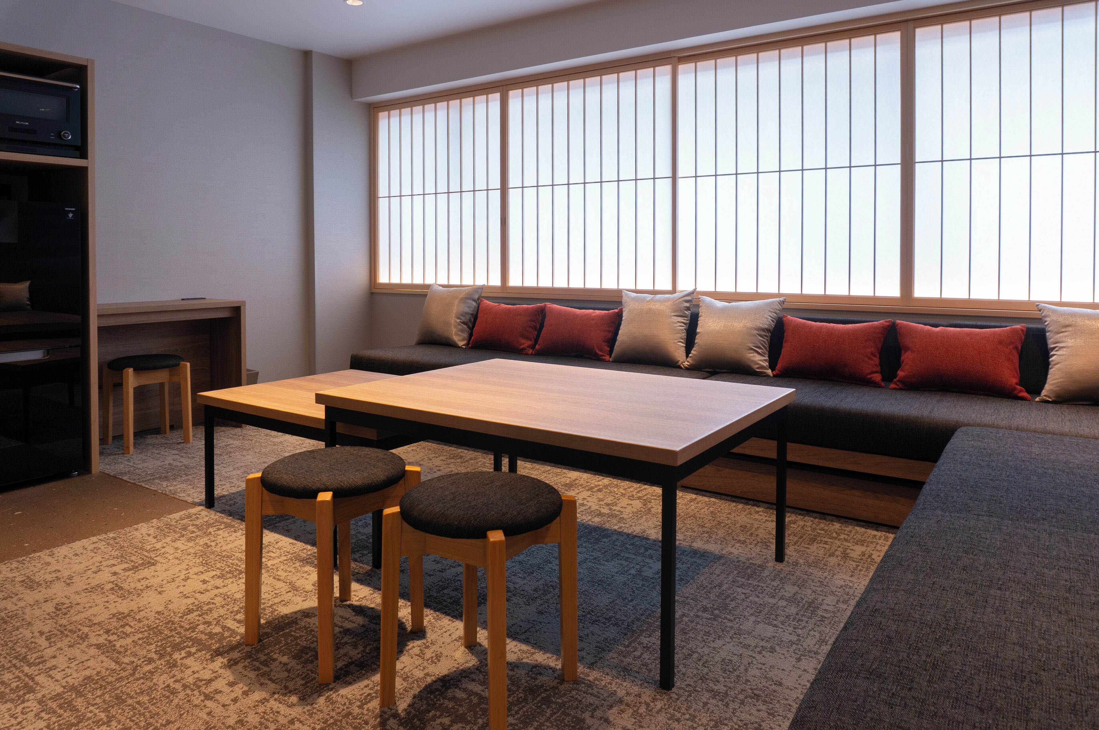 Een moderne woonkamer met een bank, een houten tafel en twee stoelen.