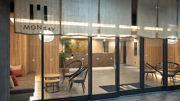 A hotel reception area with a wooden interior, a reception desk, and seating arrangements.