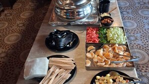 Ett bord med ett urval av olika maträtter och serveringsredskap, uppdukat som en buffé.