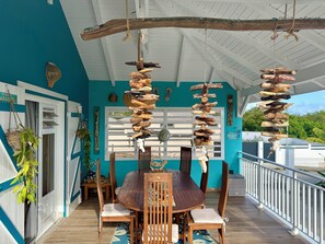A wooden dining table with chairs, a hanging wooden sculpture, and a view of the outdoors. - Villa Kaz à Colibri with swimming pool for a relaxing break with family or friends (Unknown)