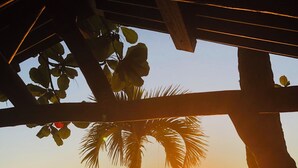 A beach scene with a sunset, palm trees, and boats on the water. - Villa Kaz à Colibri with swimming pool for a relaxing break with family or friends (Unknown)